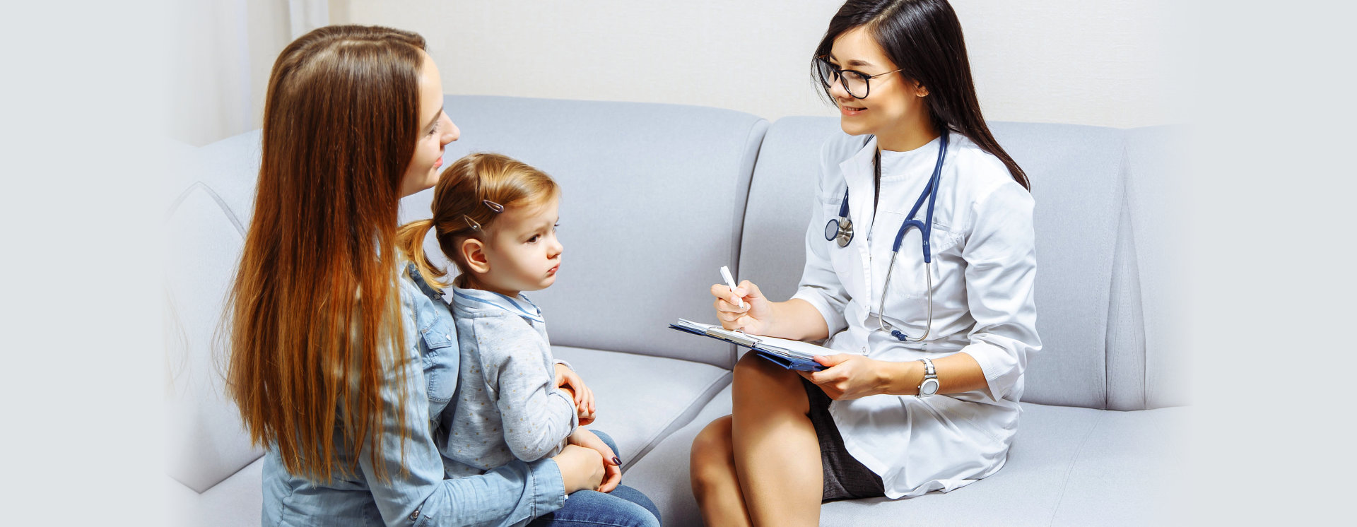 female doctor talking with a mother carrying her child